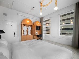 a bedroom with a large white bed and a chandelier at Symons Block Suite 7 in Spokane
