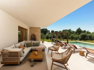 een woonkamer met een bank en stoelen en een zwembad bij Villa Casa Del Oro in Vrsar