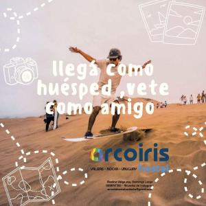 ein Poster von einem Mann, der auf einem Skateboard im Sand fährt in der Unterkunft Arcoiris Hostel in Barra de Valizas + 3 Fotos