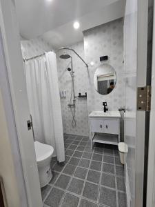 un bagno con un water, un lavandino e uno specchio di P House CNX a Chiang Mai