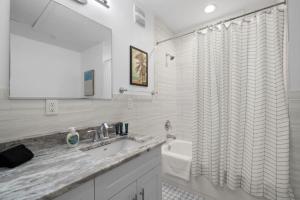 een badkamer met een wastafel en een douchegordijn bij Casa Ybor Apartments on 7th Ave in Tampa +33 foto's