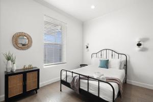 een witte slaapkamer met een bed en een raam bij Casa Ybor Apartments on 7th Ave in Tampa