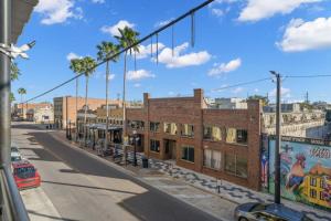 an empty city street with buildings and palm trees at Casa Ybor Apartments on 7th Ave in Tampa