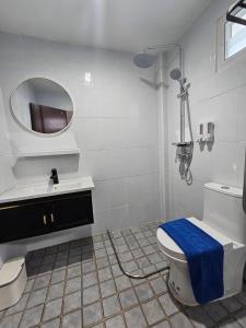 un bagno con un water, un lavandino e uno specchio di P House CNX a Chiang Mai