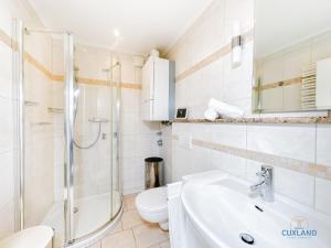 un bagno con doccia, WC e lavandino di Ferienwohnung 19 Heinrich-Grube Weg a Döse Altre 16 foto