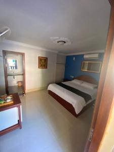 a bedroom with a large bed and a table at La Villa 23 Signature in Siem Reap