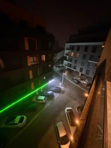 Een uitzicht op een parkeerplaats 's nachts met groene lichten. bij Genial Apartments in Gjakove