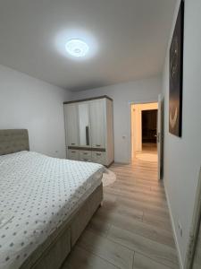 een slaapkamer met een bed en een houten vloer bij Genial Apartments in Gjakove