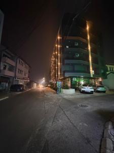 een lege straat 's nachts met een hoog gebouw bij Genial Apartments in Gjakove +4 foto's