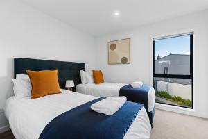 ein Schlafzimmer mit zwei Betten und einem großen Fenster in der Unterkunft Flexible Bed Options, Private Back Yard, Car Park in Albert Town