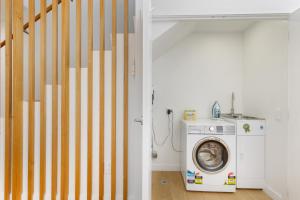 eine Waschküche mit einer Waschmaschine und einer Treppe in der Unterkunft Flexible Bed Options, Private Back Yard, Car Park in Albert Town