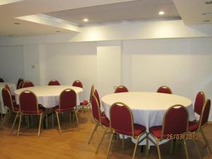Cette chambre comprend des tables blanches et des chaises rouges. dans l'établissement Torre Libertad Departamentos Amoblados, à San Isidro