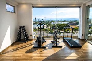 ein Fitnessstudio mit Cardiogeräten und einem großen Fenster in der Unterkunft Hotel Vía Norte Inn - Nuevo - Estacionamiento gratis - Ubicación estratégica in Tuxtla Gutiérrez + 32 Fotos