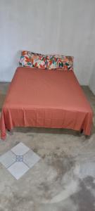 een bed met een rood laken erop bij Casa do campo Flor de pitaya in Prado