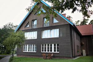 a black house with two chairs in front of it at Amber White apartment in Juodkrantė