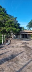 een onverharde tuin met bomen en een gebouw bij Casa do campo Flor de pitaya in Prado