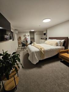 una camera da letto con un grande letto bianco in una stanza di Guest suite Sleeps 4 a New Plymouth