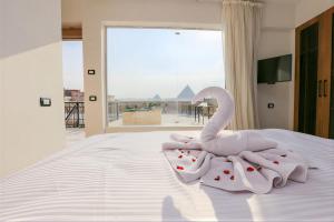 Een roze zwaan zit bovenop een bed. bij Pyramids View Hotel in Caïro +42 foto's