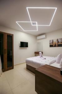 een witte kamer met 2 bedden en een televisie bij Pyramids View Hotel in Caïro