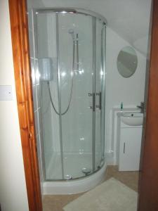 a shower with a glass door in a bathroom at Woodway B&B in Blewbury