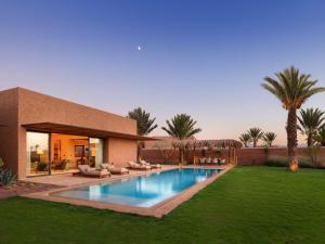ein Haus mit einem Swimmingpool im Hof in der Unterkunft Fairmont Royal Palm Marrakech in Marrakesch