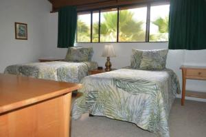 a hotel room with two beds and a window at Peaceful golf retreat with shared pools in Waikoloa Village