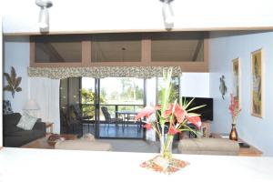 a living room with a vase of flowers on a table at Peaceful golf retreat with shared pools in Waikoloa Village