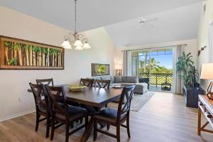 a dining room with a table and chairs and a couch at Spacious 2BR condo with lanai & pool in Waikoloa