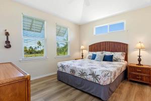 a bedroom with a bed and two windows at Spacious 2BR condo with lanai & pool in Waikoloa