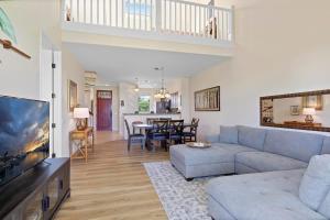 a living room with a couch and a tv at Spacious 2BR condo with lanai & pool in Waikoloa