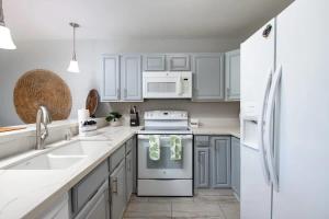 a kitchen with white appliances and white cabinets at Tropical condo with pools lanai & BBQ in Waikoloa Village