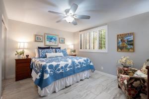 a bedroom with a bed and a ceiling fan at Tropical condo with pools lanai & BBQ in Waikoloa Village