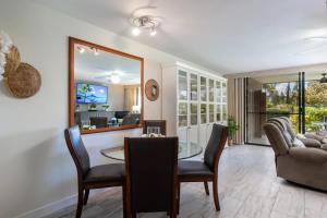 a living room with a table and chairs and a couch at Tropical condo with pools lanai & BBQ in Waikoloa Village +22 photos