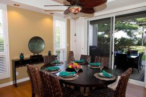 a dining room with a table with chairs and a ceiling fan at Spacious retreat with pool & private lanai in Waikoloa