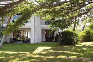 an exterior view of a white house with trees at Spacious retreat with pool & private lanai in Waikoloa