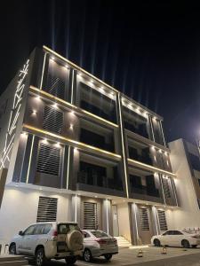 due auto parcheggiate di notte davanti a un edificio di بيتك الثاني a Abha