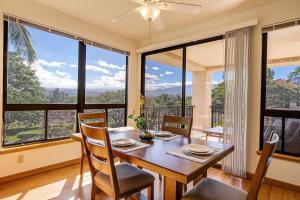 a dining room with a table and chairs and large windows at Tropical 1BR condo with pool & private lanai in Waikoloa