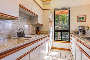 a kitchen with white cabinets and a sink at Tropical 1BR condo with pool & private lanai in Waikoloa