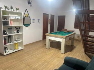 ein Zimmer mit einem Billardtisch und einem Regal in der Unterkunft Recanto do Céu in Pacoti