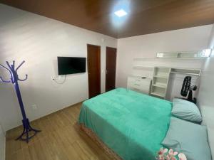 ein Schlafzimmer mit Bett und Flachbildfernseher in der Unterkunft Recanto do Céu in Pacoti
