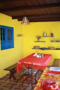 a table in a room with a yellow wall at Casa Galeguita in Pipa