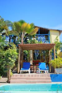 a resort with two blue chairs and a pool at Casa Galeguita in Pipa