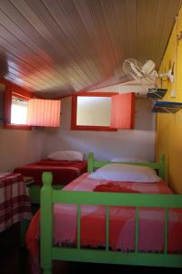 two beds in a room with red and green at Casa Galeguita in Pipa +14 photos