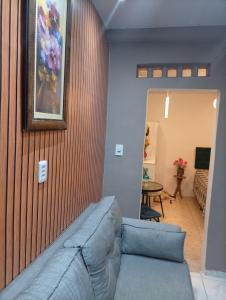 a living room with a couch and a painting on the wall at Flat aconchegante na maraponga in Fortaleza