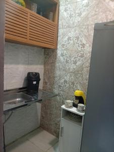 a small kitchen with a sink and a refrigerator at Flat aconchegante na maraponga in Fortaleza