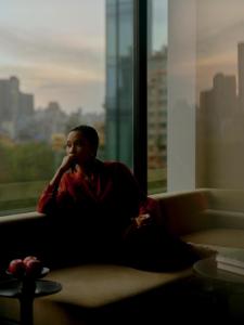 a woman sitting on a couch looking out a window at The PuLi Shanghai in Shanghai +89 photos