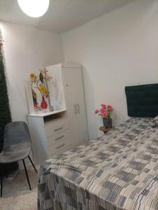 a bedroom with a bed and a cabinet and a chair at Flat aconchegante na maraponga in Fortaleza +8 photos