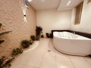 a large bathroom with a tub and plants in it at Glory Pyramids Inn in Cairo +72 photos