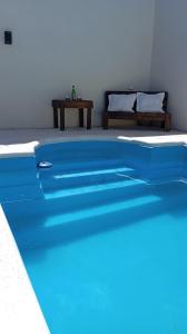 een blauw zwembad in een kamer met een bed bij Quincho Russo in Cerrillos