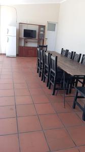 een eetkamer met een houten tafel en stoelen bij Quincho Russo in Cerrillos